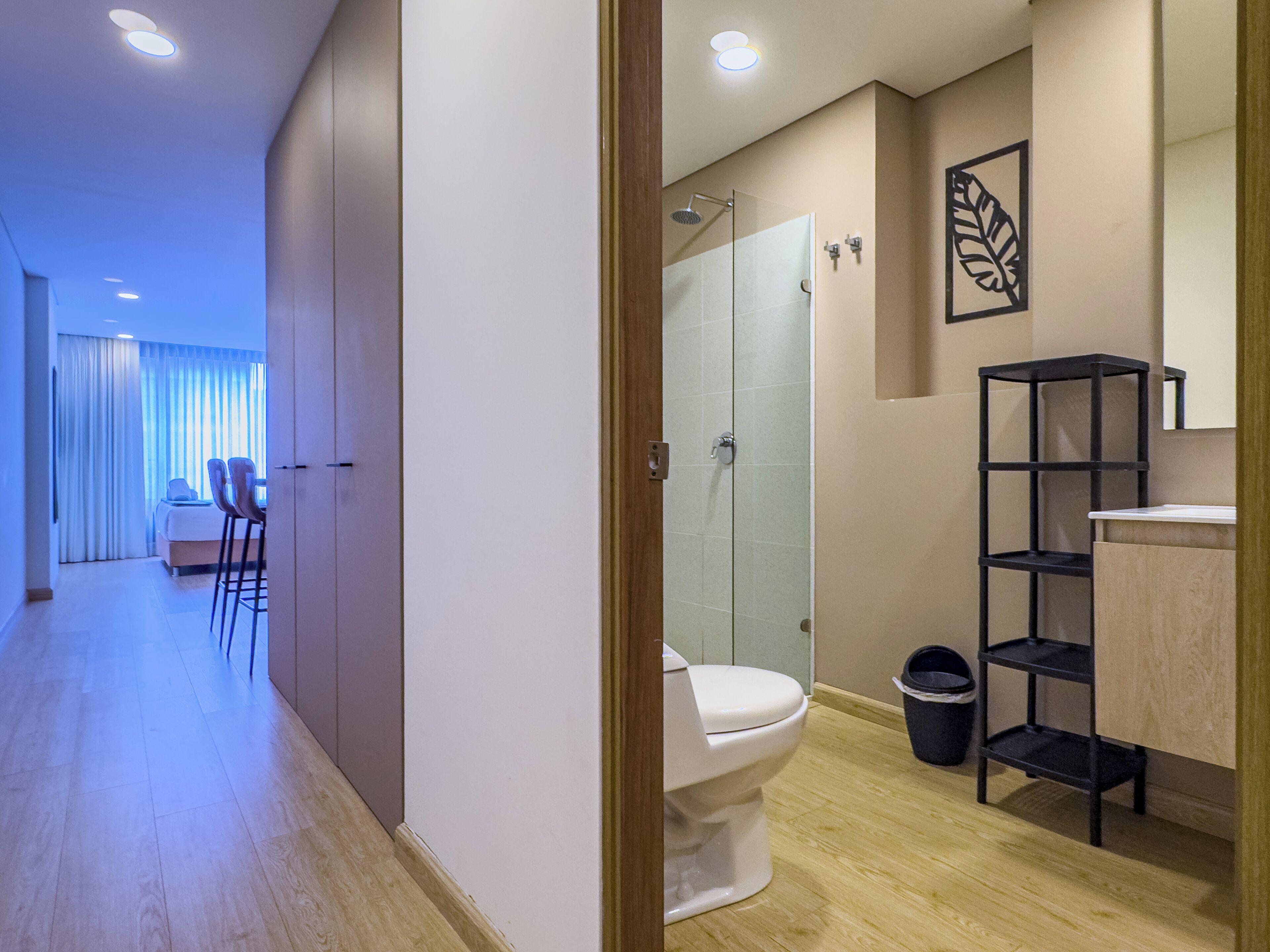 Un bagno moderno con toilette, doccia e un mobile contenitore nero.