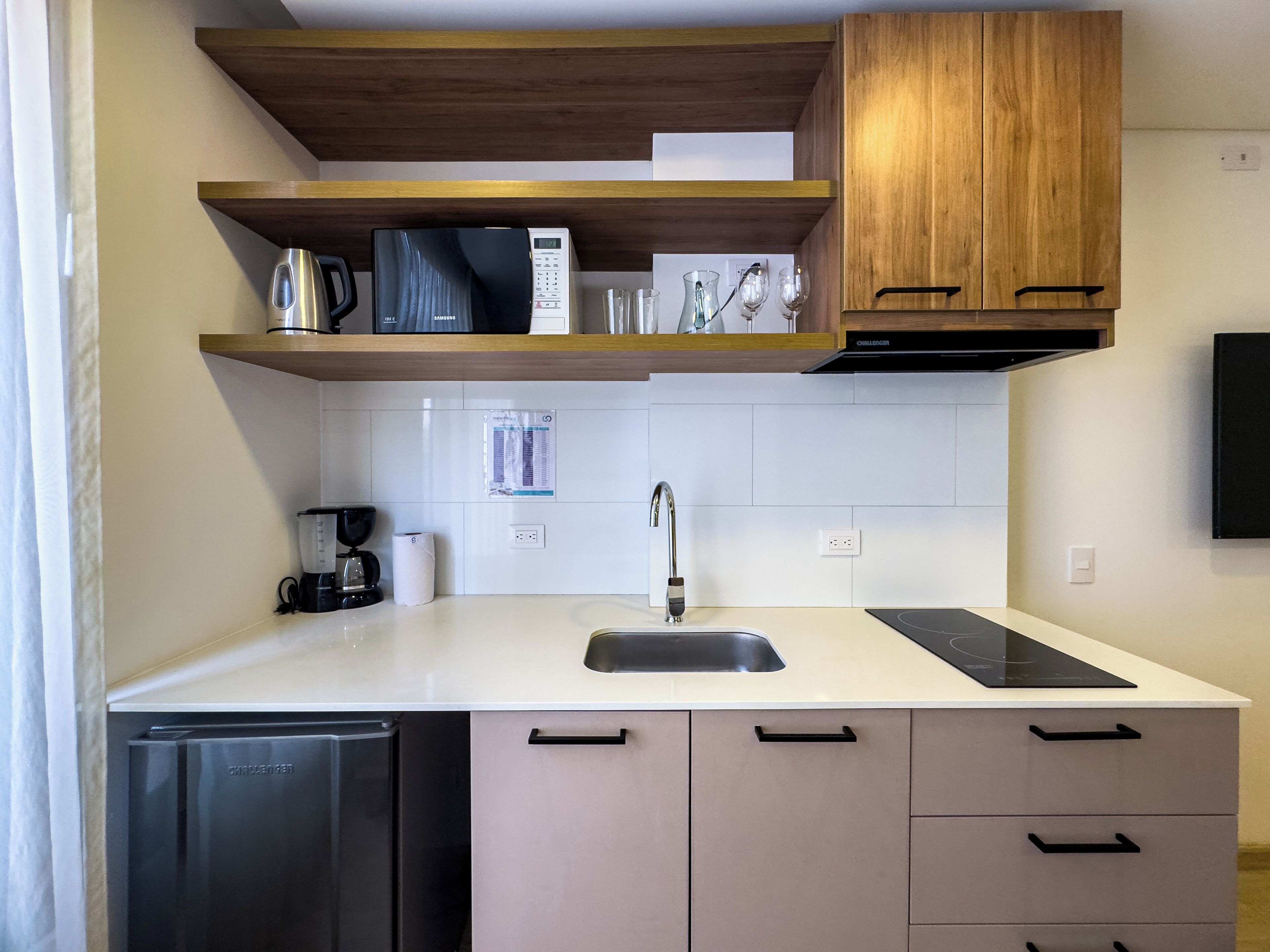 A modern kitchen with a dishwasher, a coffee maker, a sink, and wooden cabinets.