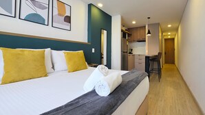 Una camera d'albergo con un letto, una scrivania e angolo cottura.