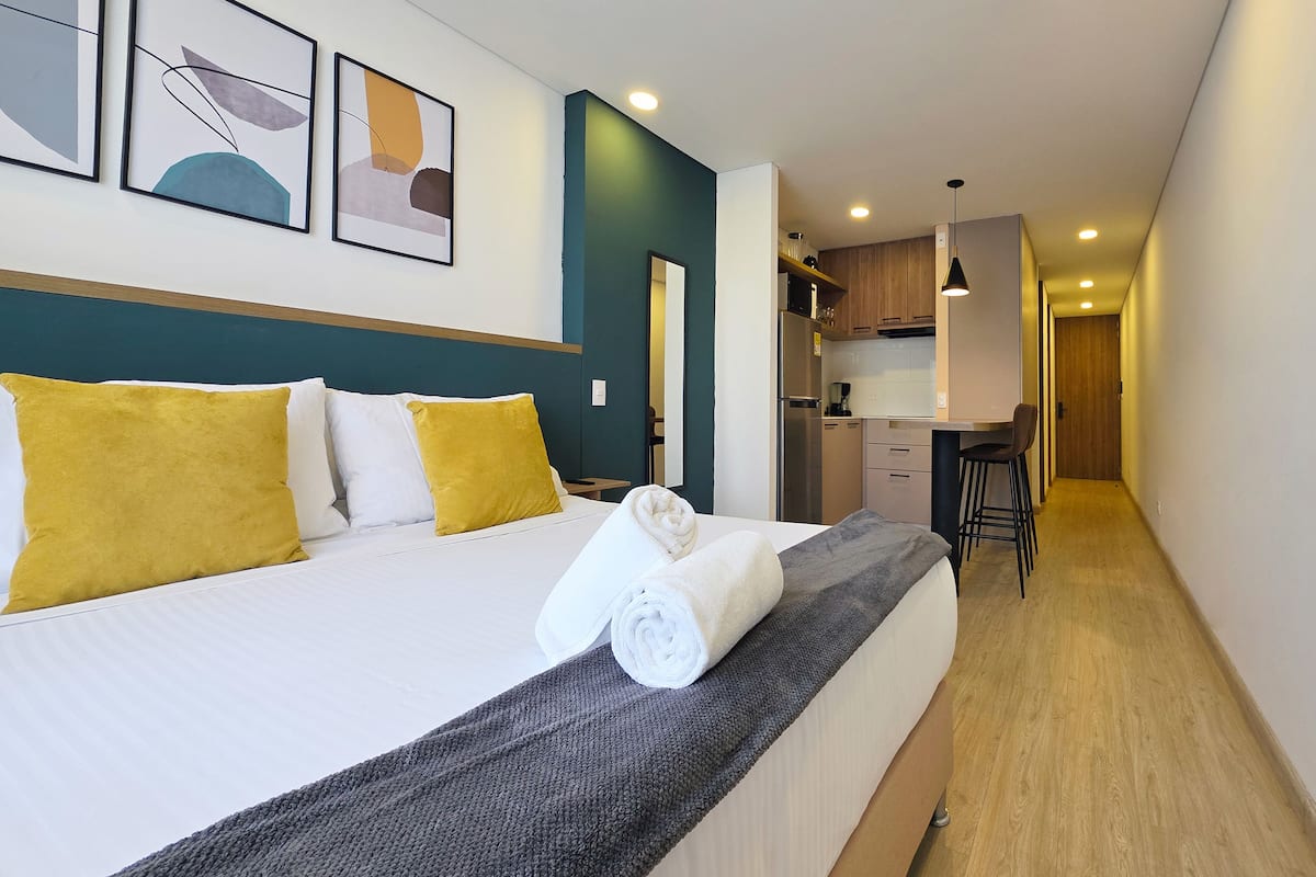 Une chambre d’hôtel avec un lit, un bureau et une kitchenette.