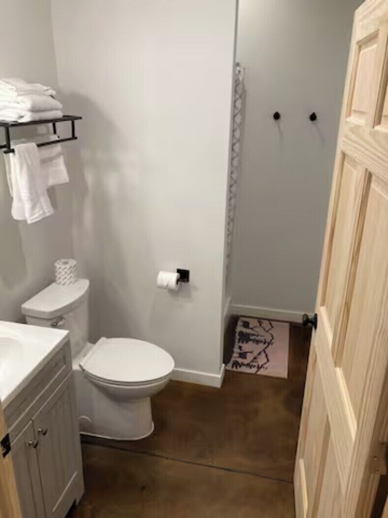 Ein Badezimmer mit Toilette, Waschbecken und Handtuchhalter.