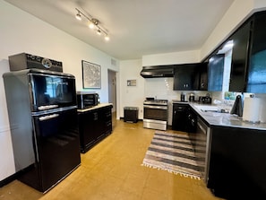 Fully equipped kitchen with a refrigerator, oven, microwave, and dishwasher.
