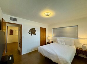 Relax in a serene space with a large bed, bedside tables, and a window with blinds.