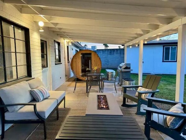Relax in this inviting patio area with a sofa, bench, and dining table, perfect for al fresco dining and socializing.
