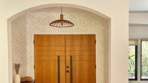 A wooden wardrobe with two doors, a hanging light fixture, and a patterned rug in a hallway with wooden flooring. - Designer Retreat w/ Hot Tub, Huge Backyard Oasis (Santa Cruz)
