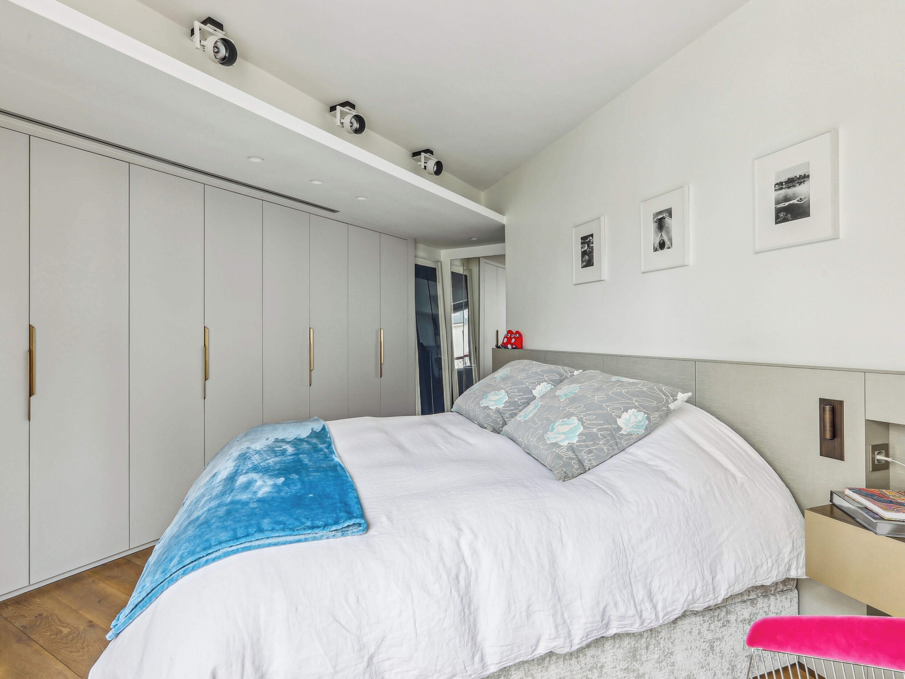 Une chambre à coucher avec un grand lit, une armoire et une table de chevet.