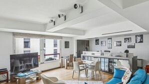 Un salon moderne équipé d’un téléviseur, de sièges et d’un coin repas.