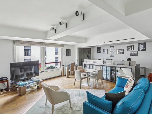 A modern living room with a TV, seating, and a dining area. - Quai des Célestins  1bdr by B'Your Home (Paris)