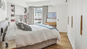 Une chambre moderne avec un grand lit, un bureau en bois et une bibliothèque.