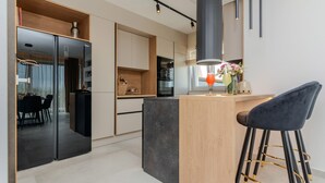 Cocina moderna con una isla central, electrodomésticos negros y una zona de bar con taburetes.