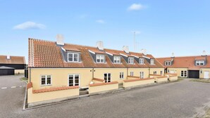 Un hilera de edificios residenciales con tejados a dos aguas y ventanas de dormer.