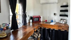 A compact kitchen with a wooden countertop, a microwave, and a sink.