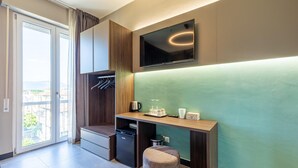 A modern kitchenette with a built-in oven, a coffee maker, and a small table.