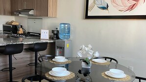 A modern kitchen with a built-in stove, a water dispenser, and a welcome sign.