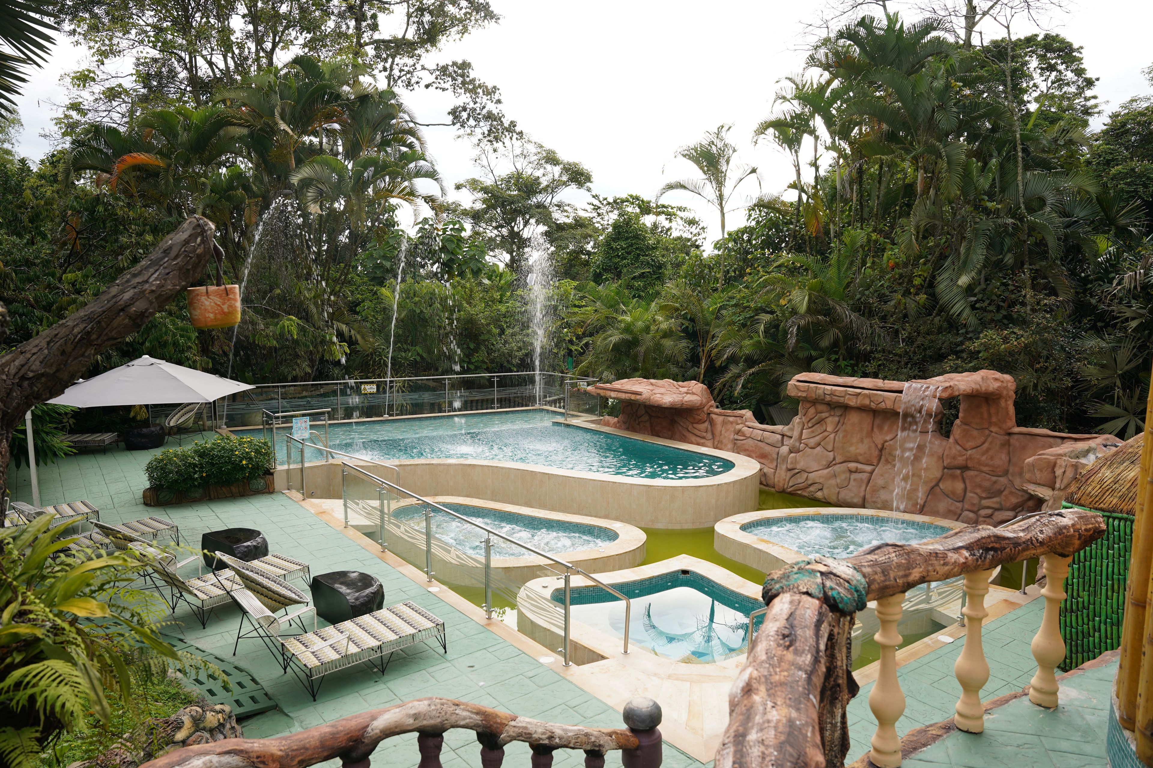 A pool area with multiple pools, lounge chairs, and a waterfall feature.