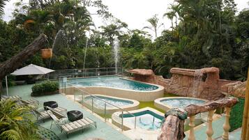 A pool area with multiple pools, lounge chairs, and a waterfall feature.