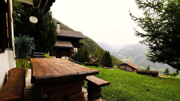 A rustic wooden bench and table set against a mountainous backdrop. - Charming detached cottage for up to 5 people. It has a good location close to a shuttle bus stop tha (St-Luc)