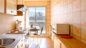 Una cocina con un ventanal grande, un microondas y un lavabo.