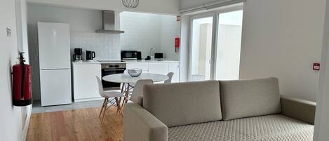 A modern apartment with a kitchenette, a dining area, and a living room with a sofa.