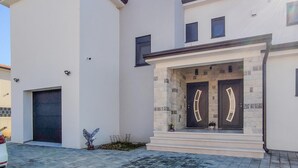 A modern two-story house with a black door and a small porch.