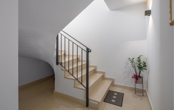 A modern staircase with a black metal railing, beige steps, and a small potted plant on the landing. - Lovely apartment in Porec with WiFi (Porec)