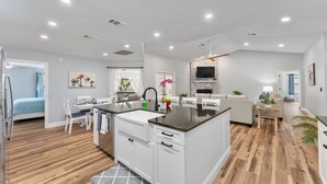 Una cocina moderna con armarios blancos, encimera de granito y horno empotrado.