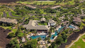 A resort with multiple swimming pools, a large central building, and surrounding landscaped areas. - Waikoloa | Big Island Getaway | Pool & Resort (Waikoloa Village)