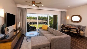 Un salon moderne comprenant un canapé, une table basse, un téléviseur et un coin repas avec des chaises.