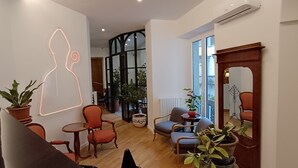 A modern living room with a wooden floor, a large mirror, and several potted plants. - Deluxe Spaccanapoli (Naples)