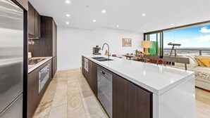 Una cocina moderna con una isla central, un área de comedor con vistas y un espacio de sala con un telescopio.