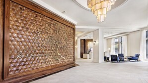 A spacious lobby with a geometric wall design, a chandelier, and seating area. - Charleston | Couples Historic Retreat | Gym + Downtown (Charleston)