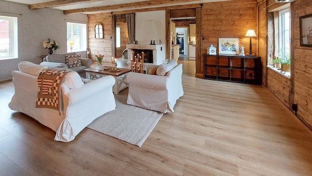 Un salón espacioso con chimenea, vigas de madera y una zona de estar acogedora.