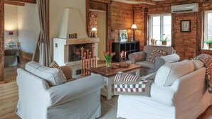 Una sala de estar acogedora con chimenea, dos sofás, una mesa de centro y un televisor.