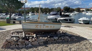 A marina with several boats docked, a small boat named "Klemtno" in the foreground, and a clear sky. - Holiday apartment with panoramic sea views (Klimno)