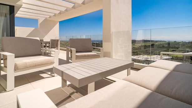 Un espace extérieur moderne, aménagé pour se détendre, avec vue sur la campagne.