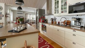 A modern kitchen with white cabinetry, a wooden countertop, a built-in oven, and a stainless steel sink. - Awesome home in Värnamo with kitchen (Värnamo)
