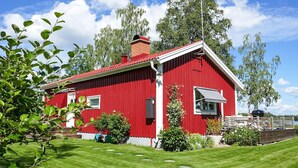 A red wooden house with a white trim, a chimney, and a small porch with a white awning. - Awesome home in Värnamo with kitchen (Värnamo)