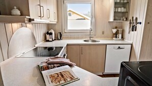 A compact kitchen with a window, a sink, a coffee maker, and a cookbook on the counter. - Nice home in Nørre Nebel with sauna (Nørre Nebel)
