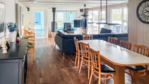 A spacious living area with a dining table, sofas, and a large clock on the wall. - Nice home in Nørre Nebel with sauna (Nørre Nebel)