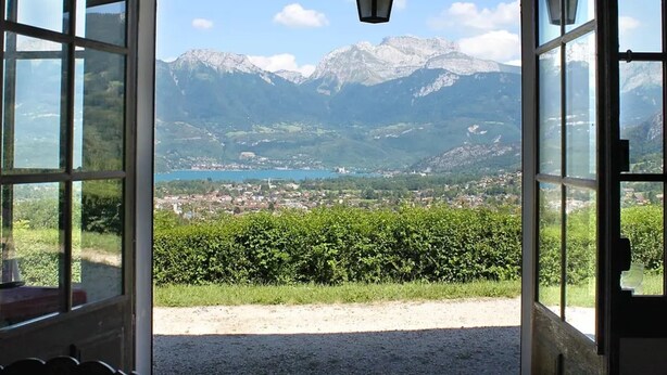 Ein Durchgang, der auf eine Berglandschaft mit einer Stadt darunter blickt.