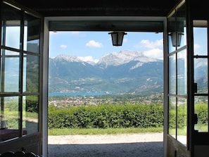Una puerta que da a una vista de un paisaje montañoso con un pueblo abajo.
