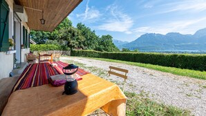 Ein überdachter Außenbereich mit Tisch, Stühlen und einer Laterne.