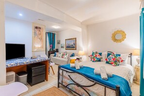 Une chambre à coucher avec un lit, un bureau, une télévision et une chaise.