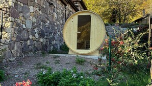 Un bâtiment en pierre avec une structure en bois en forme de tonneau à l’avant.