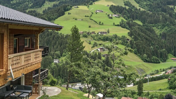 Un chalet en bois doté d’un balcon donnant sur une vallée.