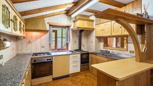 Eine Küche mit Holzausstattung, einem Herd und einem Spülbecken.