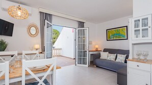 Ein modernes Wohnzimmer mit Essbereich, einer Couch und einem Schrank mit Glastüren.