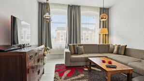 A modern living room with a sofa, coffee table, and television. - Lovely apartment in Malchow with WiFi (Malchow)