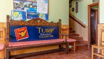 A wooden bench with a sign for 'TURF Virginia Cigarettes' and a map on the wall.