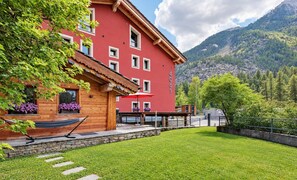 Ein rotes Gebäude mit vielen Fenstern und einer Holzterrasse.